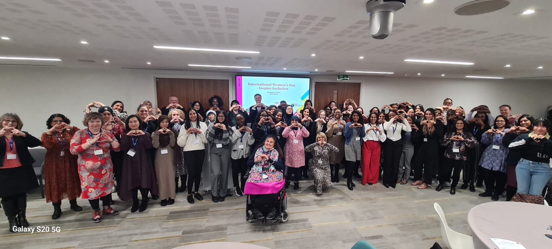 group photo of people making heart shapes with their hands